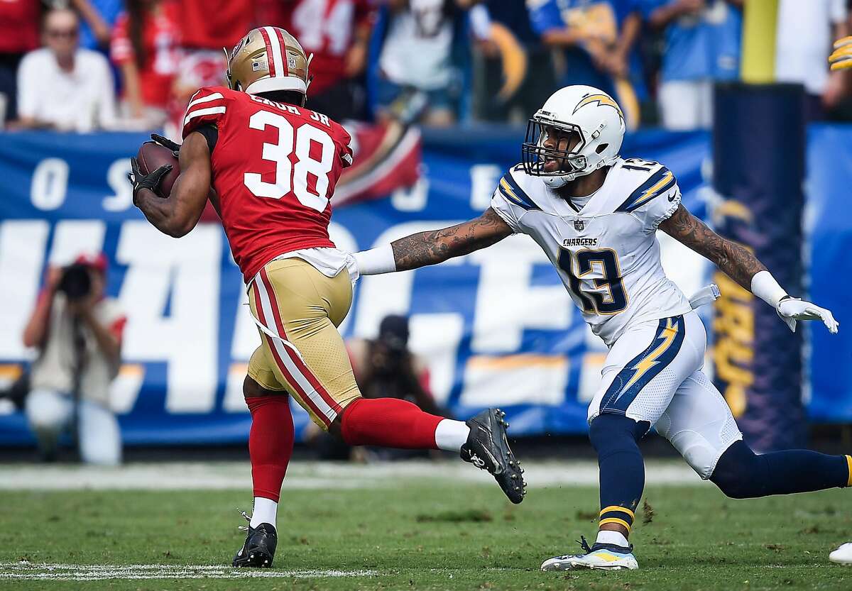 Defensive back Antone Exum #38 of the San Francisco 49ers dodges wide receiver Keenan Allen #13 of the Los Angeles Chargers to score a touchdown in the first quarter at StubHub Center on September 30, 2018 in Carson, California.