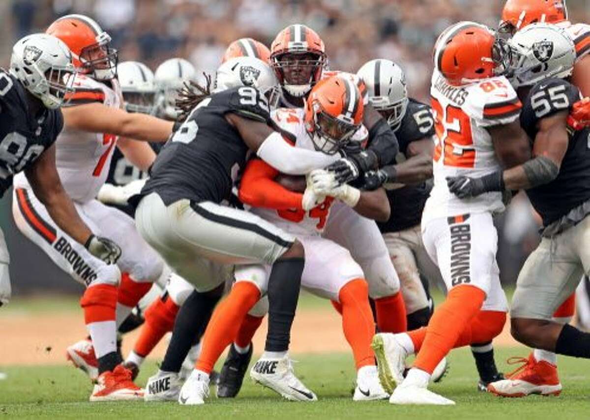 Oakland Raiders' Fadol Brown wraps up Cleveland Browns' Carlos Hyde in 3rd quarter of Raiders' 45-42 overtime win during NFL game at Oakland Coliseum in Oakland, Calif. on Sunday, September 30, 2018.
