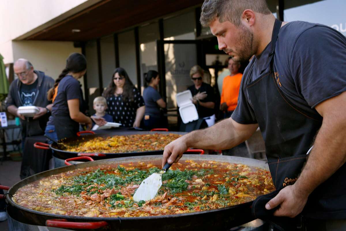 Casey Tompkins of Gerard's Paella makes food for families at Santa Rosa, Calif., on Monday, September 24, 2018. Heather Irwin, a local food critic, started Sonoma Family Meal to provide meals to victims from last year's wildfires. She and a group of volunteers partner with local restaurants to serve weekly meals.