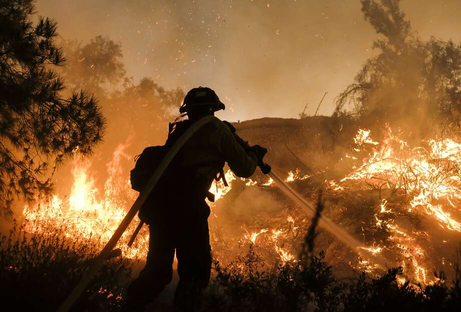FILE - In this Aug. 9, 2018, file photo, a firefighter battles the Holy Fire burning in the Cleveland National Forest along a hillside at Temescal Valley in Corona, Calif. California is in the midst of another devastating year of wildfires and finding the causes for the worst of them can be critical to identifying better fire-prevention techniques. But often investigators can’t figure out a cause. (AP Photo/Ringo H.W. Chiu, File) Photo: Ringo H.W. Chiu / Associated Press