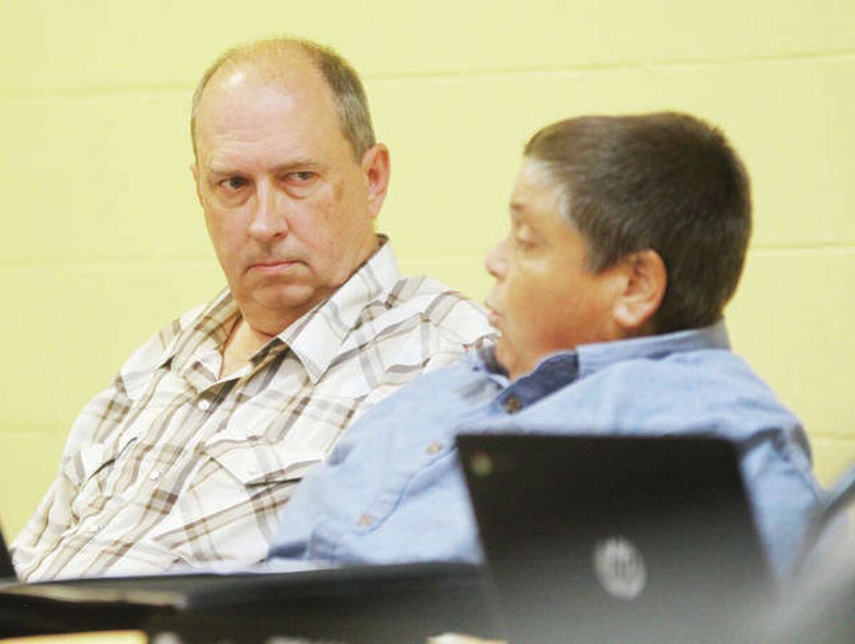 Godfrey Village Board Member Mark Stewart, left, listens as fellow Trustee Joseph Springman talks at a past board meeting during discussion on the potential sale of the village’s wastewater sewer system to Illinois American Water Co. The village is expected to vote on the sale of the sewer system at Tuesday’s meeting.