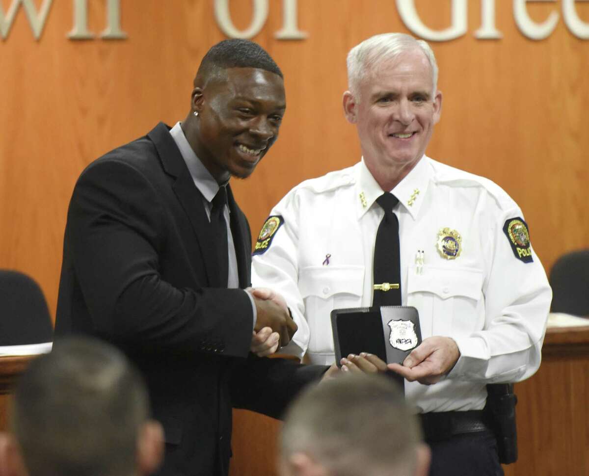 New Greenwich police officer Allen Arrington, left, receives his badge from Chief of Police James Heavey at the swearing-in ceremony for new Greenwich police officers at Town Hall in Greenwich, Conn. Monday, Oct. 1, 2018. Five new police recruits - Allen Arrington, Kevin Ingraham, Christopher Manjuck, William O'Connor and Erica Rosario - were sworn in on Monday.