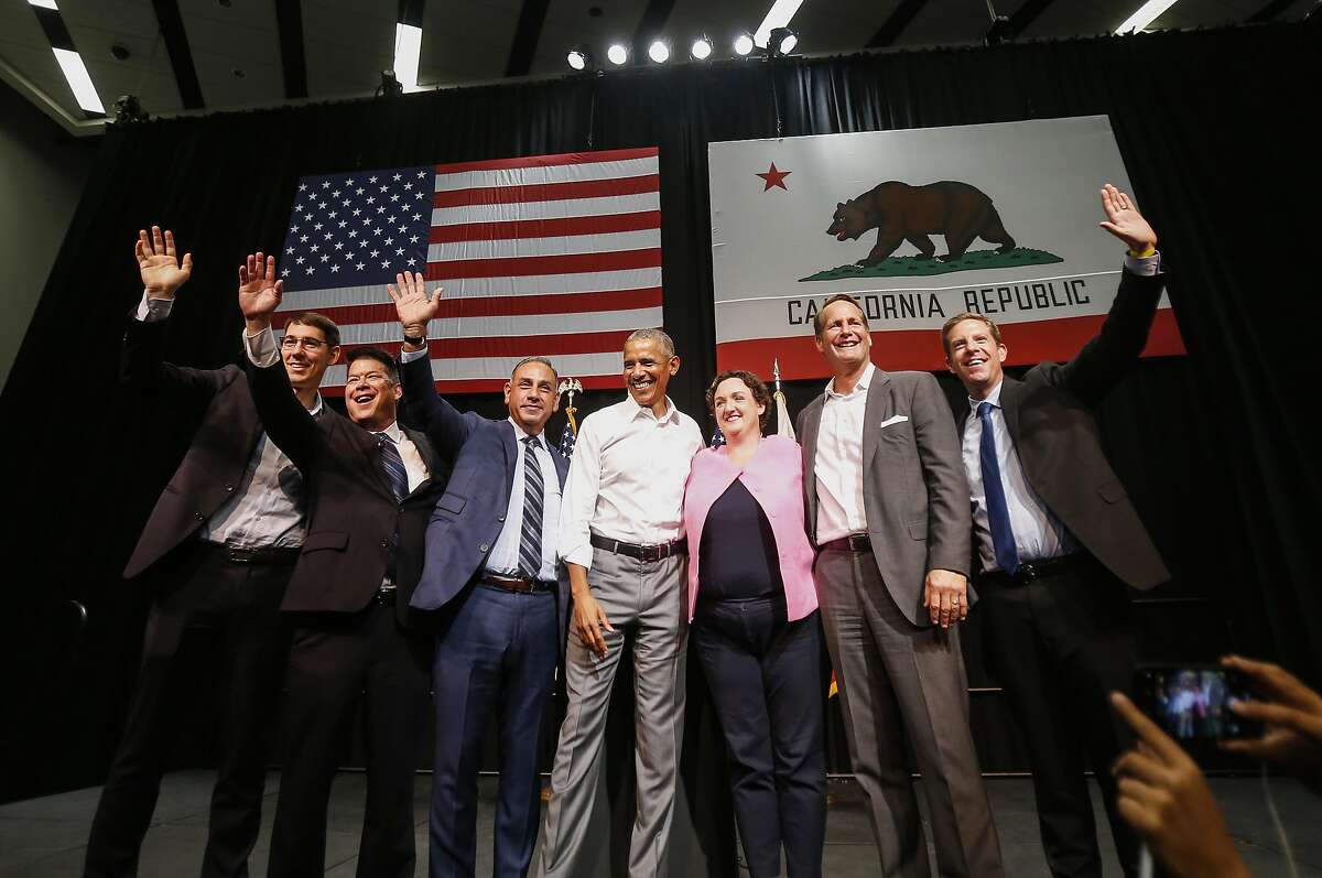 President Barack Obama, center, with congressional candidates, from left, Josh Harder, TJ Cox, Gil Cisneros, Katie Porter, Harley Rouda and Mike Levin wave to supporters as Obama campaigns in support of California congressional candidates, Saturday, Sept. 8, 2018, in Anaheim, Calif. (AP Photo/Ringo H.W. Chiu)