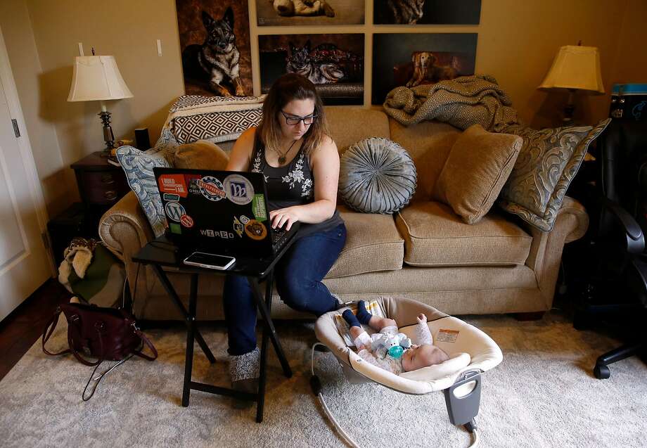 Melissa Geissinger works on her laptop while keeping an eye on her son Ollie at her parents' Sebastopol home on Wednesday, April 11, 2018. Geissinger and her husband, Cole, moved into the home after their Santa Rosa home was destroyed in the Tubbs Fire. Photo: Guy Wathen / The Chronicle