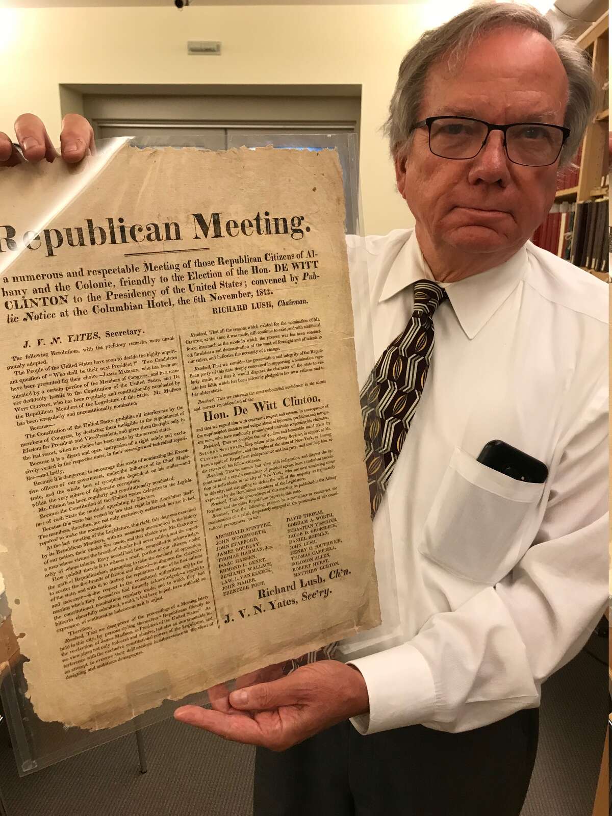 Political items collector Tom Keefe holds up a broadside from the DeWitt Clinton collection at the Albany Institute of History & Art.