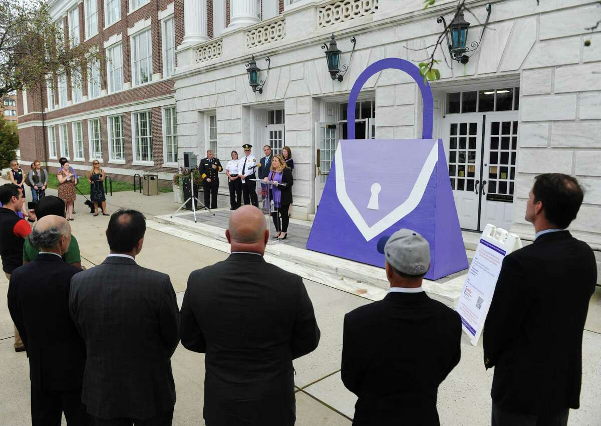 YWCA Greenwich Director of Domestic Abuse Services Meredith Gold speaks beside a large purple purse, the symbol of domestic abuse, during the Domestic Violence Awareness and Prevention Month Kickoff at Town Hall in Greenwich, Conn. Tuesday, Oct. 2, 2018. Representatives from the YWCA's domestic abuse services and Chief of Police James Heavey spoke about the prevelance of domestic violence and the importance of outreach services for victims. First Selectman Peter Tesei also read a proclamation to commemorate the start of Domestic Violence Awareness and Prevention Month. Events continue throughout the month including a candlelight vigil, art show reception, movie night and shopping event.