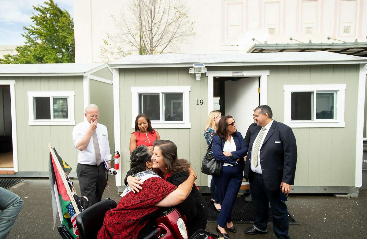 Oakland Mayor Libby Schaaf hugs a supporter, who gave her name as Na, while visiting Tuff Shed shelters adjacent to the Kaiser Convention Center in Oakland on Tuesday, Oct. 2, 2018. The city plans to house up to 40 homeless people in the shelters as part of it's third Community Cabin site.