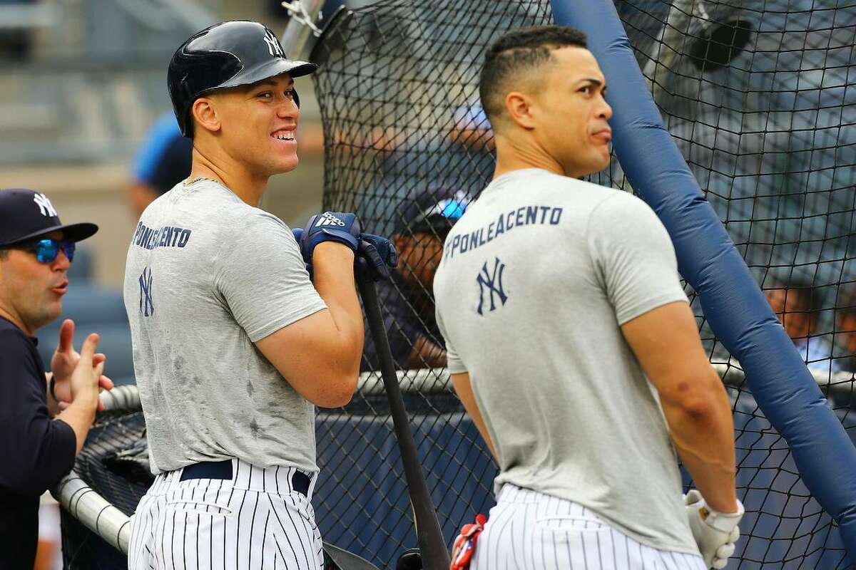 Aaron Judge (with batting helmet) and Giancarlo Stanton are two of the Yankees’ power hitters. They helped New York set a record with 267 homers.