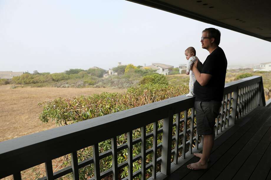 Cole Geissinger holds his son Ollie while giving a tour of their rental home in Bodega Bay on Saturday, August 18, 2018. Photo: Guy Wathen / The Chronicle