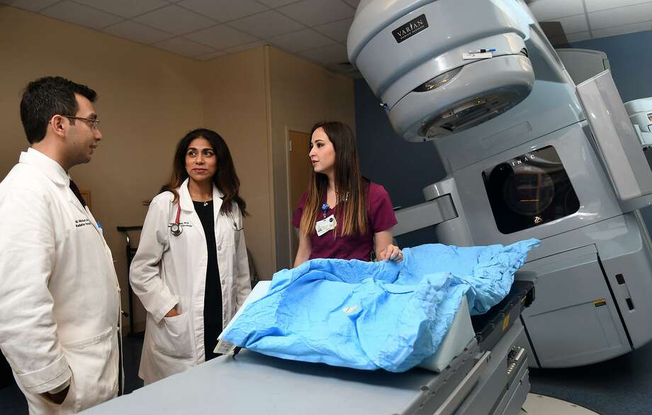 Dr. Ali Mazloom, from left, and Dr. Uzma Iqbal, both physicians at Cypress Fairbanks Medical Center's Cancer Center, chat with radiation therapist Nallely Sandoval about the linear accelerator at the Cancer Center. Photo: Jerry Baker, Freelance / For The Chronicle / Freelance