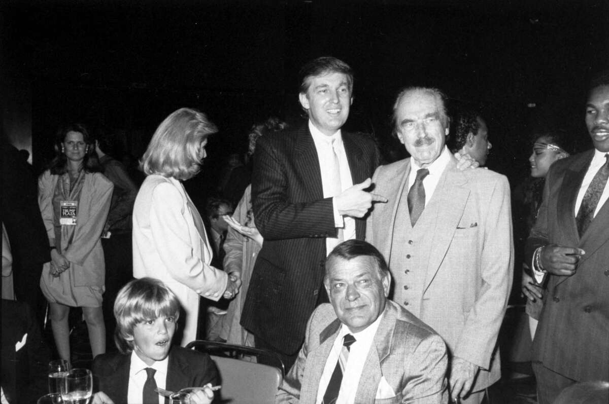 Real estate magnate Donald Trump (C) w. his wife Ivana (2L) & young son, Donald Jr.(L-seated), chatting w. his developer/builder dad, Fred Trump as they mingle w. others at Tyson/Spinks pre-fight party in the Trump Plaza hotel. (Photo by Time Life Pictures/DMI/The LIFE Picture Collection/Getty Images)