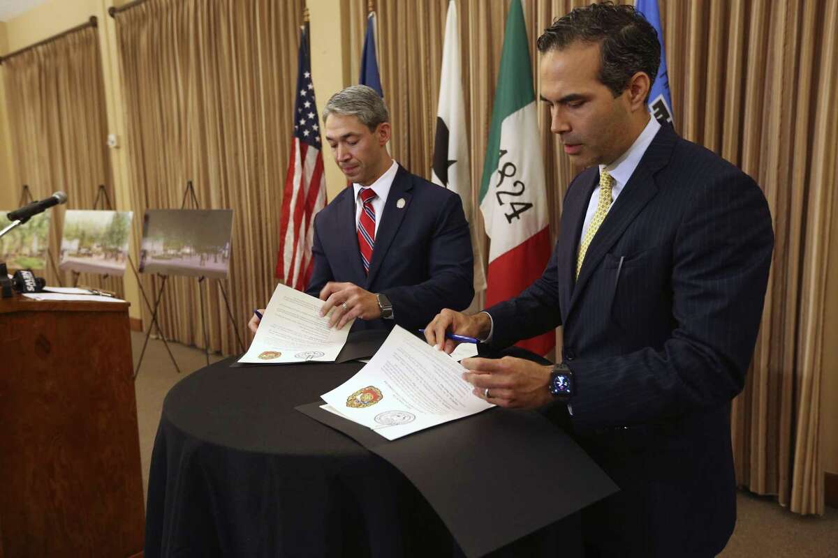 San Antonio Mayor Ron Nirenberg, left, and Texas Land Commissioner George P. Bush sign a resolution Oct. 2, 2018, agreeing on the general terms of the Alamo master plan which includes the closing of Alamo Street through Alamo Plaza and moving the Cenotaph to a different location in the plaza.