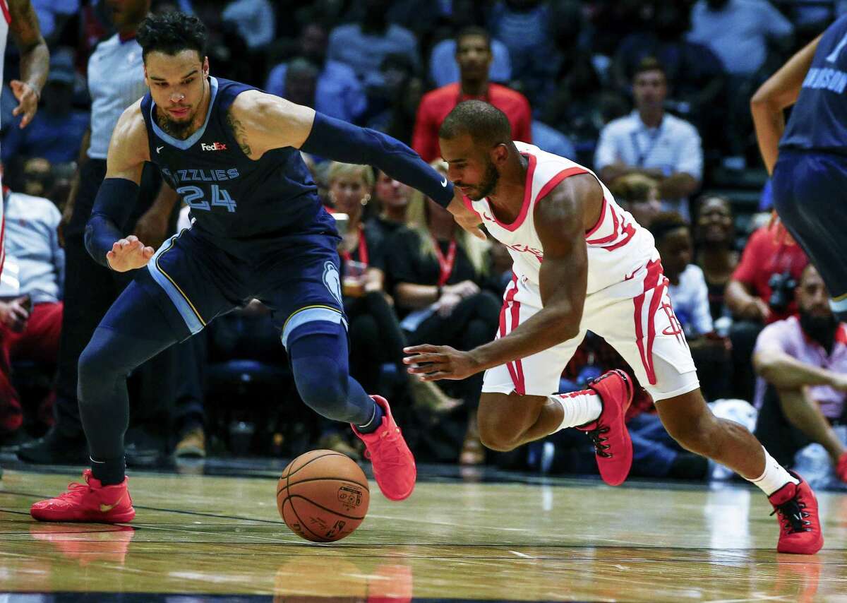 Rockets guard Chris Paul, right, and the Grizzlies’ Dillon Brooks scramble for a loose ball during the first half Tuesday night.