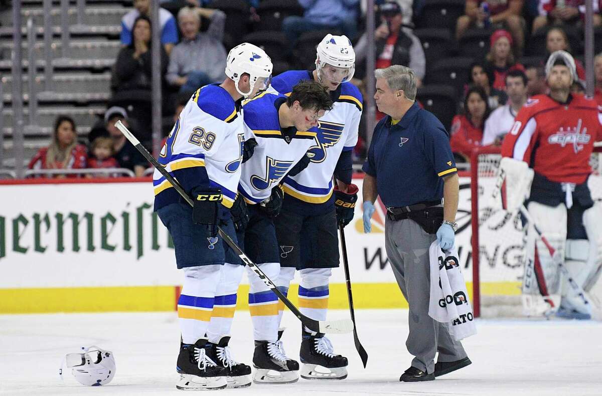 St. Louis Blues center Oskar Sundqvist, second from left, is helped off the ice by right wing Dmitrij Jaskin (23) and defenseman Vince Dunn (29) during the second period of an NHL preseason hockey game after he was checked by Washington Capitals' Tom Wilson, Sunday, Sept. 30, 2018, in Washington. (AP Photo/Nick Wass)