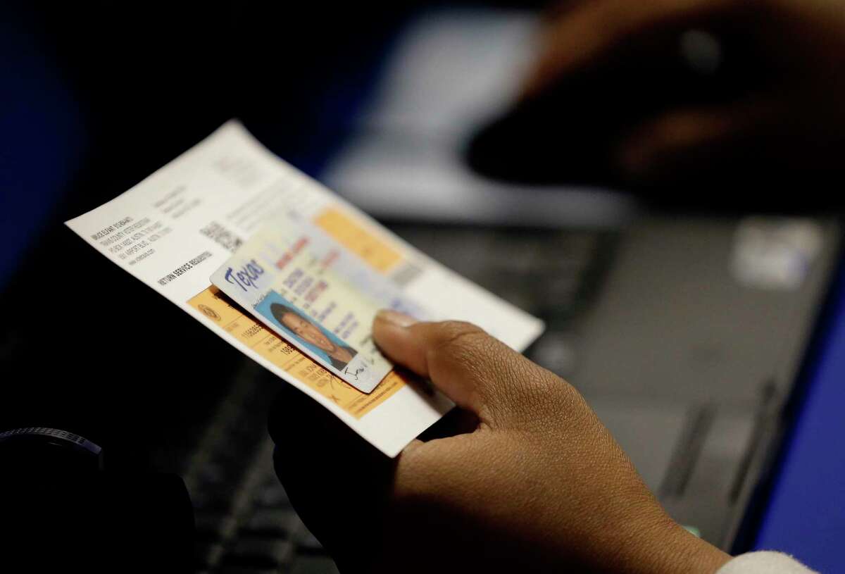 An election official checks a voter's photo identification at an early voting polling site in Austin, Texas. >>See how Texas and its voters ranked during the last midterm elections...