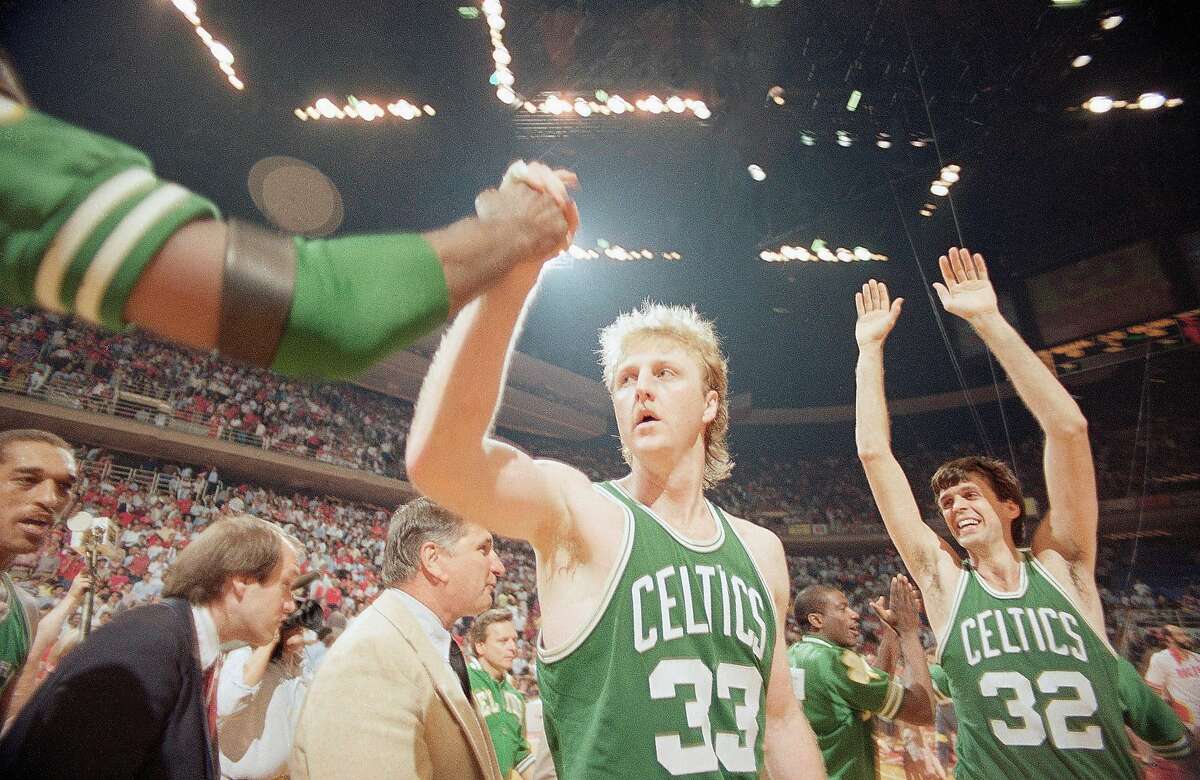 Boston Celtics Larry Bird (33) gets a congratulation as teammate Kevin McHale (32) goes up with his arms in victory over the Houston Rockets in game four by score of 106-103, Tuesday, June 4, 1986, Houston, Tex. (AP Photo/F. Carter Smith)