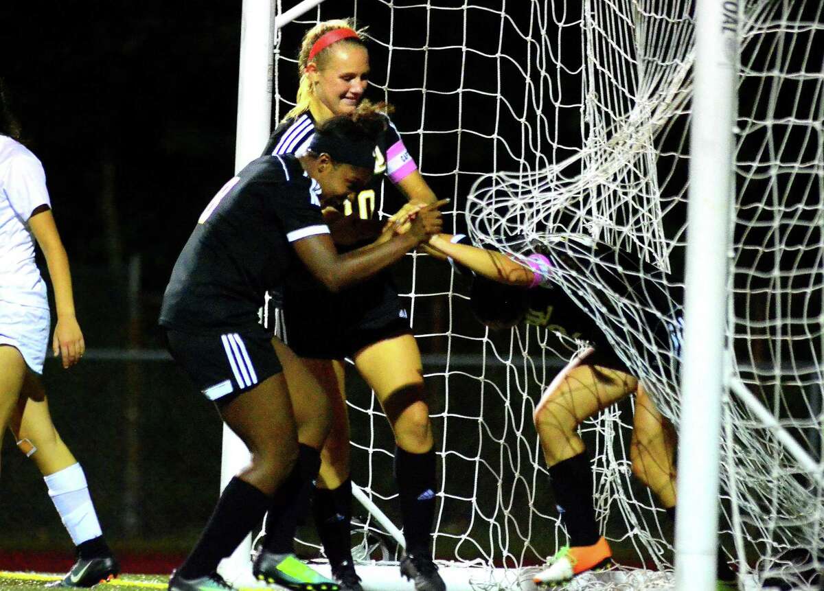 Jonathan Law’s Jocelyn Wirth, right, gets help from her teammates after Wirth scored a goal against Foran Wednesday night in Milford.
