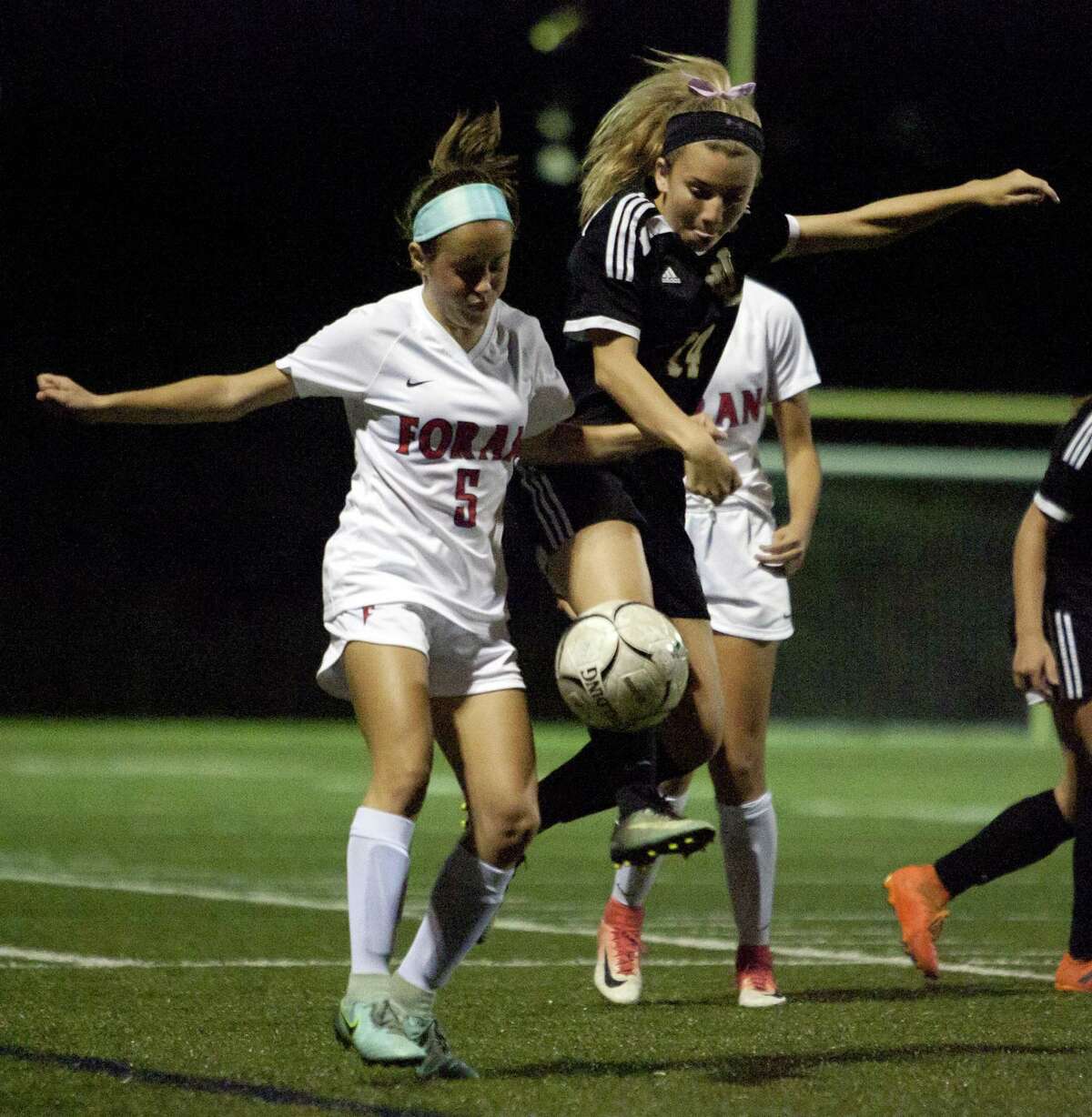 Jonathan Law's Skylar Sosa, right, leaps in to intercept the ball in front of Foran's Isabel Morales during girls soccer action in Milford, Conn., on Wednesday Oct. 3, 2018.