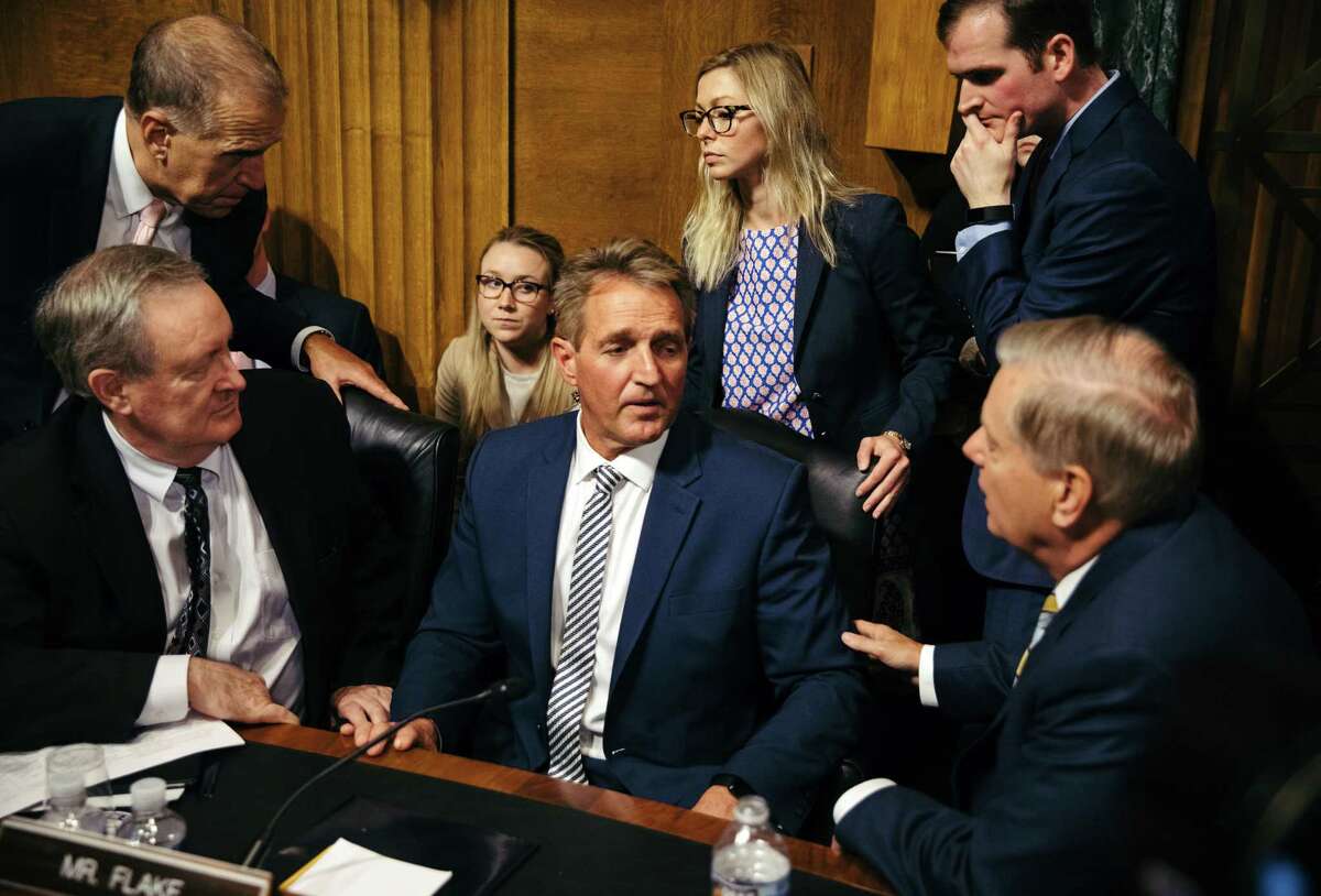 Senate Judiciary Committee member Sen. Jeff Flake, center, speaks with colleagues after a hearing Friday on the nomination of Brett Kavanaugh. Flake and three other senators remain undecided.