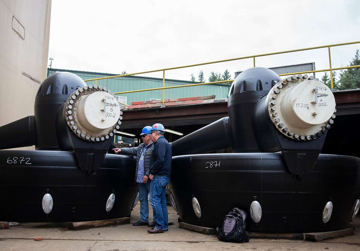 Peter Zwart, VP of Operations for Baydelta Maritime and Matt Nichols, EVP of Nichols Brothers Boat Builders, take a look at the boat's two US255 azimuth thrusters at Nichols Brothers Boat Builders on Whidbey Island, Monday, Sept. 17, 2018 in Freeland, Washington. The multipurpose tractor tugboat will be the first with a hybrid propulsion system used on the West Coast, using a Rolls-Royce Z-drive that can operate as full diesel, full electric or as diesel-electric.