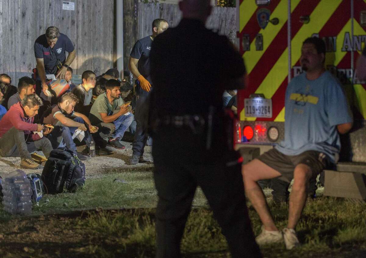 Gerardo Carreon, in handcuffs, sits on the back step of an ambulance on June 12 near Loop 410 and Broadway where a group of undocumented immigrants sought to escape when the tractor-trailer rig Carreon was driving was approached by law enforcement. Several immigrants were injured as they ran. Carreon was sentenced Thursday to 5 years and 10 months in federal prison on a charge of conspiracy to transport undocumented immigrants.