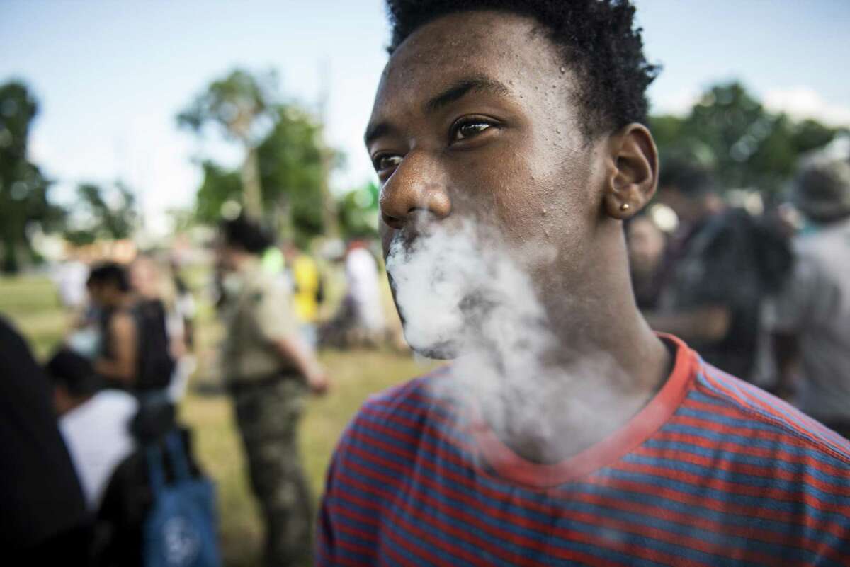 A man who gave his name as "Jazz," smokes a joint during a march held by San Antonio NORML, a chapter of the National Organization for the Reform of Marijuana Laws, at their first rally and march, in support of reforming marijuana laws in Texas held downtown on Sunday, May 3, 2015. "This is civil disobedience," Jazz said.