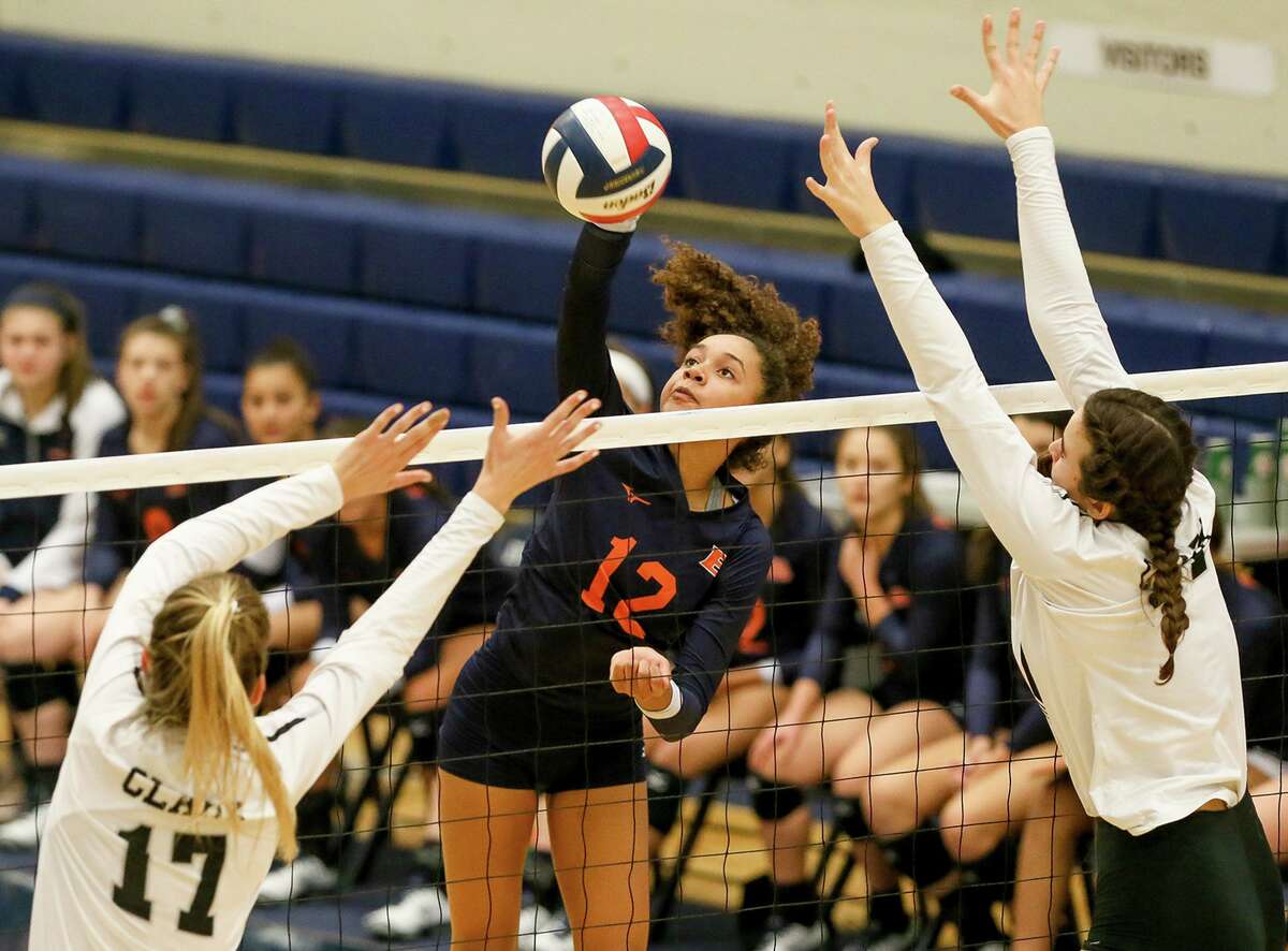 Brandeis' Jalyn Gibson hits the ball past Clark's Kara McGhee (left) and Elsie McGhee during their District 28-6A high school volleyball match at Taylor Fieldhouse on Tuesday, Oct. 2, 2018.