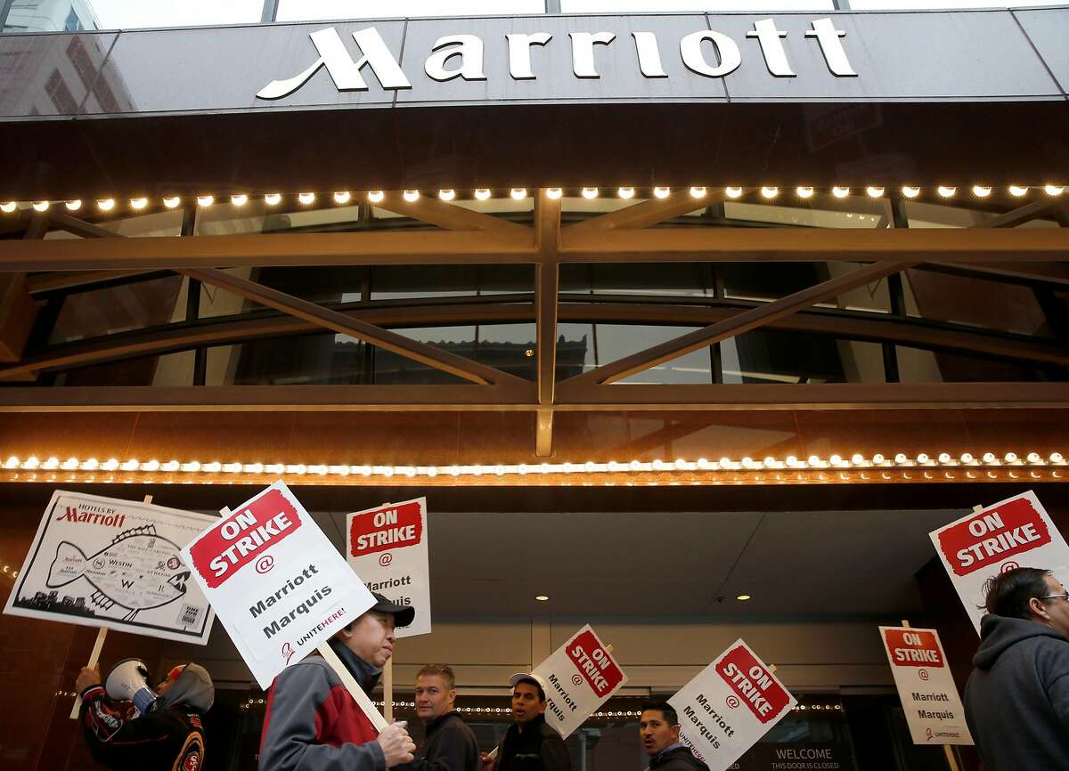 Hotel workers walk a picket line outside of the Marriott Marquis hotel at Fourth and Mission streets as thousands of workers walked off the job in a contract dispute in San Francisco, Calif. on Thursday, Oct. 4, 2018.