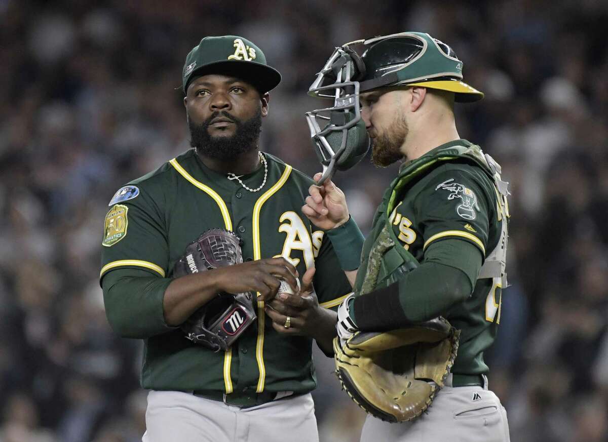 Oakland Athletics relief pitcher Fernando Rodney, left, and catcher Jonathan Lucroy wait on the mound as Rodney is relieved during the sixth inning of the American League wild-card playoff baseball game against the New York Yankees, Wednesday, Oct. 3, 2018, in New York. (AP Photo/Bill Kostroun)