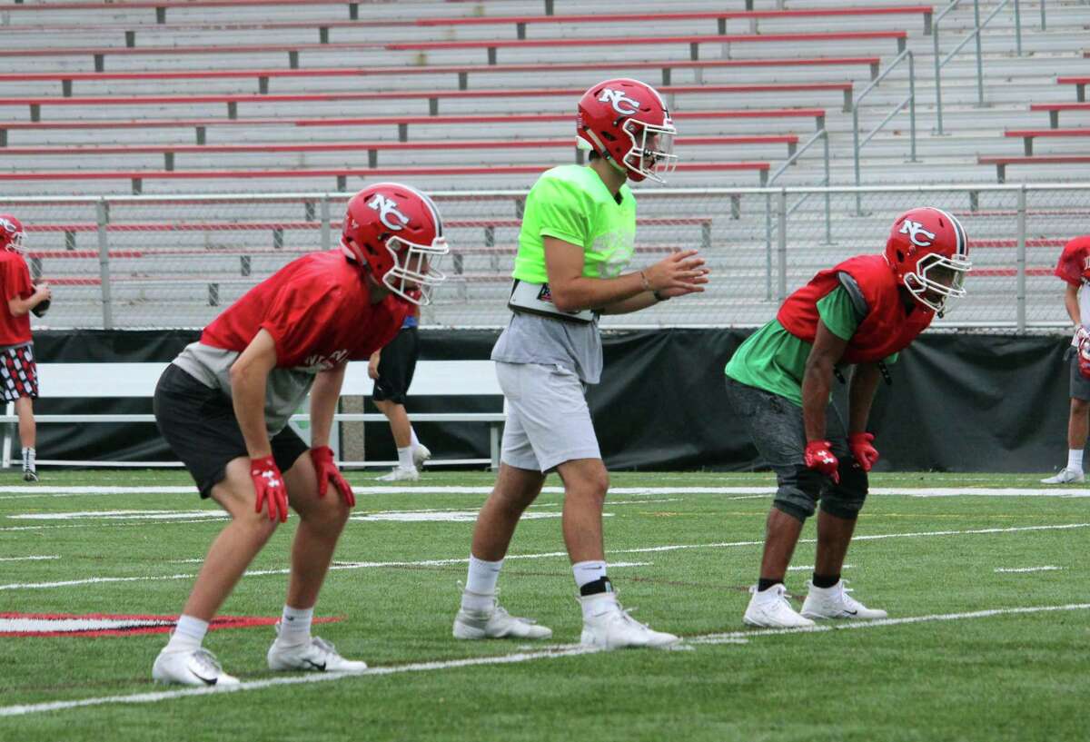 New Canaan quarterback Drew Pyne is flanked by running backs Christian Sweeney (left) and J.R. Moore (right) during a New Canaan practice on Thursday, Oct. 4, 2018 at New Canaan High School in New Canaan, Conn.