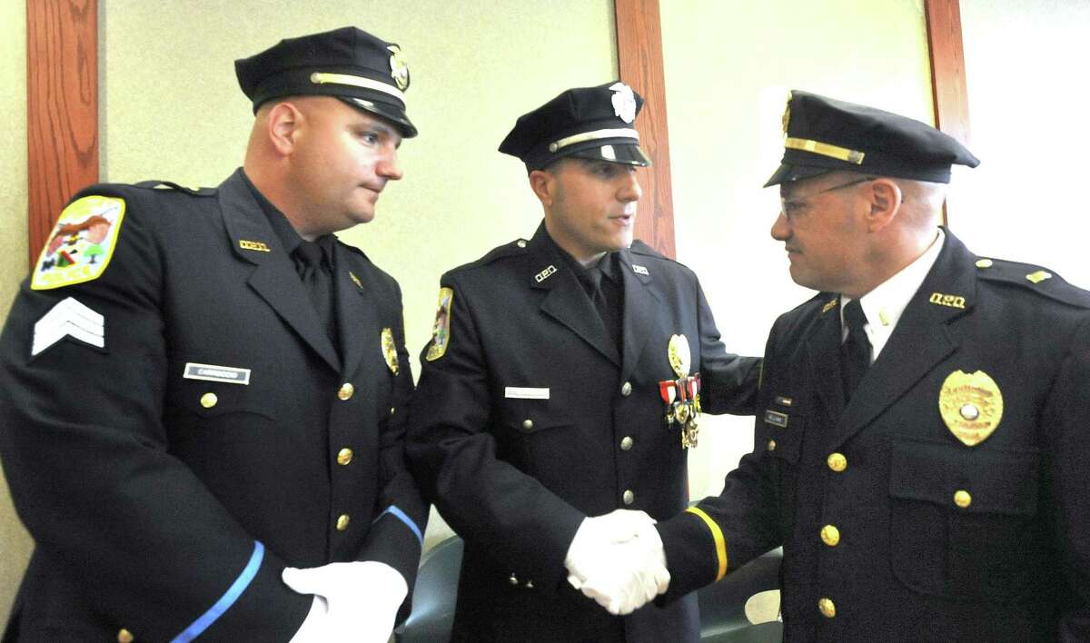 Lt. Christian Carroccio, left, Detective Len LaBonia, and Lt. Mark Williams, right, are all promoted during a ceremony at the Danbury Police Department Thursday, Sept. 15, 2011.