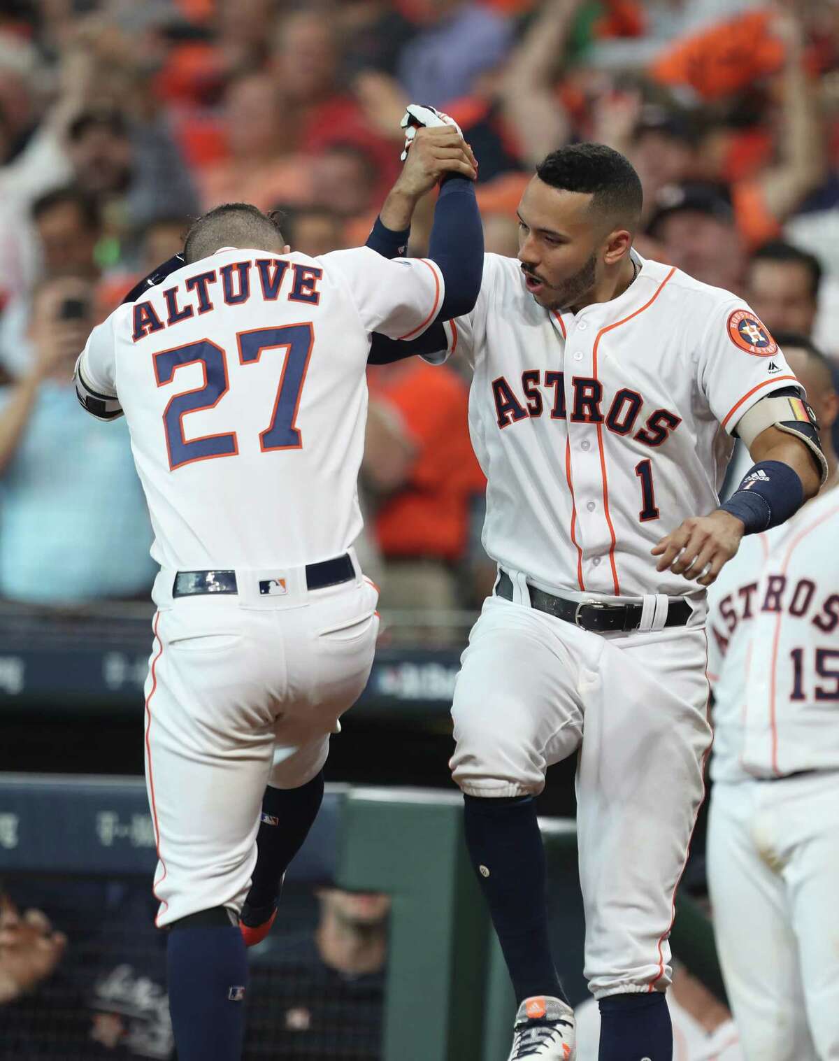 Houston Astros shortstop Carlos Correa (1) and Houston Astros second baseman Jose Altuve (27) celebrate in the fifth inning of Game 1 of the American League Division Series at Minute Maid Park on Friday, Oct. 5, 2018, in Houston.