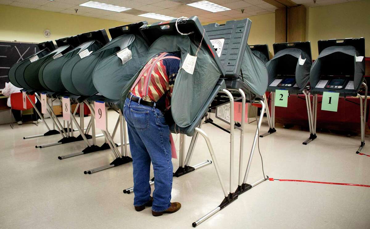 FILE -- Richard DeLosSantos, an election clerk, prepares voting booths at the Metropolitan Multi-Services Center in Houston, May 27, 2014. The Supreme Court on May 26, 2015, agreed to hear a case that will answer a long-contested question about a bedrock principle of the American political system: the meaning of "one person one vote." (Cody Duty/Houston Chronicle via The New York Times) -- NO SALES