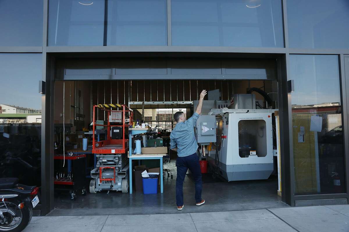 Brett Swope, owner Swope Design Solutions, opens a rolling door onto Channel Street at Swope Design Solutions at 150 Hooper on Friday, October 5, 2018 in San Francisco, Calif.