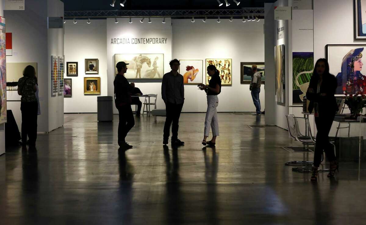 Visitors stroll through the gallery displays during the Texas Contemporary Art Fair at the George R. Brown Convention Center on Friday, Oct. 5, 2018, in downtown Houston.