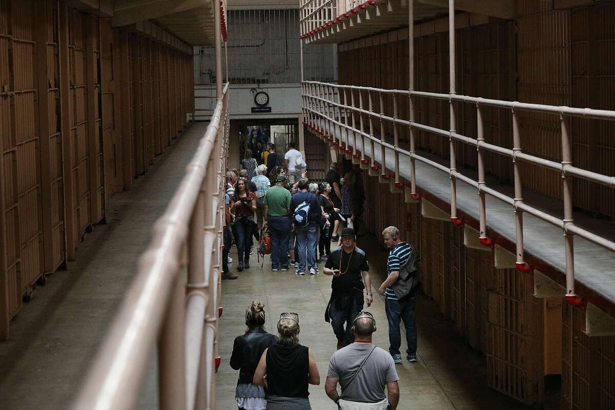 Visitors to Alcatraz walk past the jail cells on Wednesday, October 3, 2018 in San Francisco, Calif.