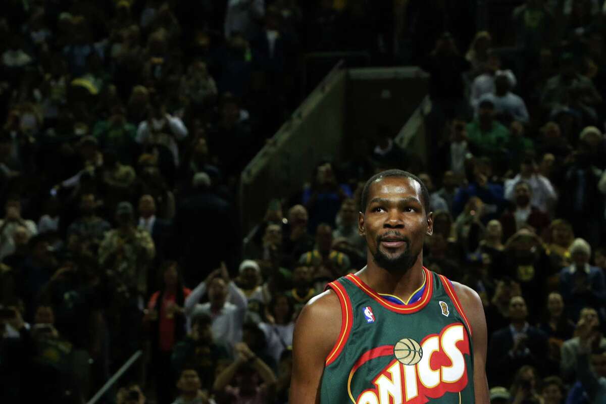 Wearing a Shawn Kemp SuperSonics jersey, Golden State Warrior Kevin Durant addresses the crowd before the start of the Warriors NBA preseason game against the Sacramento Kings at KeyArena, Friday, Oct. 5, 2018.