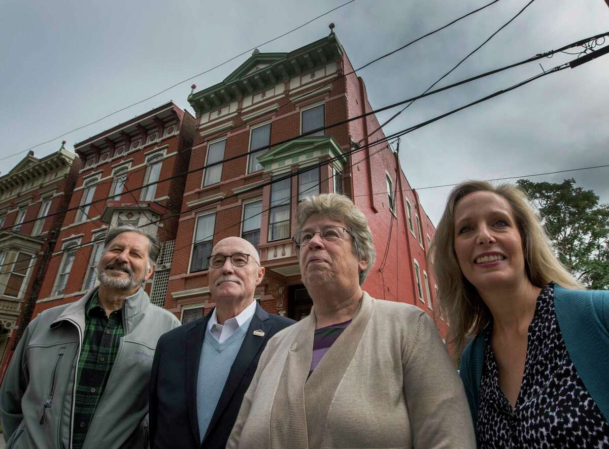 Four former and present executive directors of TRIP stand in front of a row houses on Old 6th Avenue Wednesday Oct. 3, 2018 in Troy, N.Y. Former executive directors are from left; Vinny Lepera, Duncan Barrett,and Barbara Jones Higbee and the present executive director Christine Nealon stand to the right of the former directors. (Skip Dickstein/Times Union)