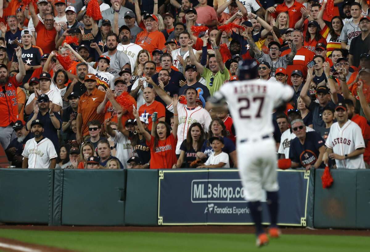Fans react after Houston Astros second baseman Jose Altuve (27) singles on a ground ball to Cleveland Indians third baseman Josh Donaldson (27) in the sixth inning of Game 2 of the American League Division Series at Minute Maid Park on Saturday, Oct. 6, 2018, in Houston.