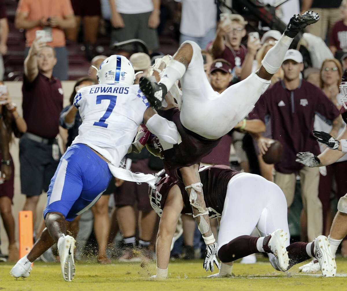 Texas A&M running back Trayveon Williams (5) dives over tight end Trevor Wood (80) to score and win an NCAA college football game as Kentucky safety Mike Edwards (7) defends in overtime of an NCAA college football game Saturday, Oct. 6, 2018, in College Station, Texas. (AP Photo/Michael Wyke)