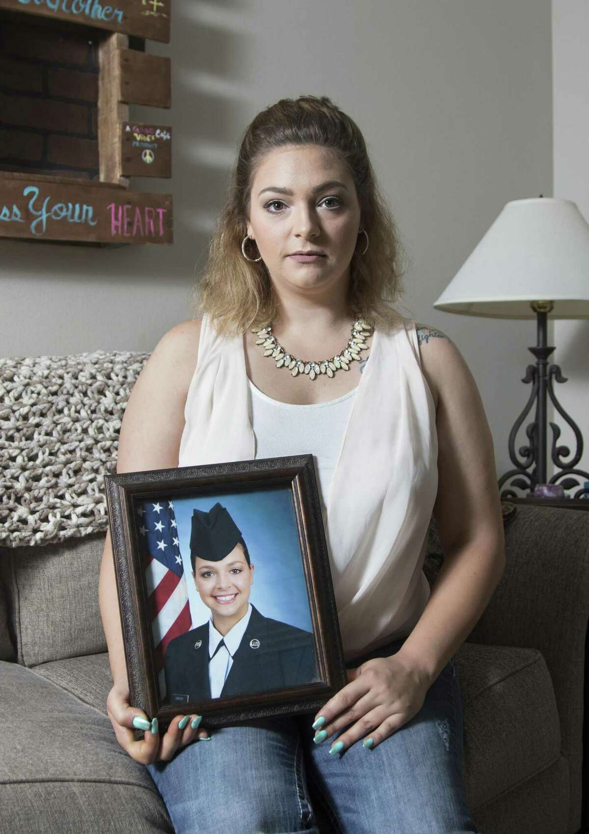 Former Air Force recruit Virginia Messick holds a portrait of herself in uniform at her home in Baker, Florida on Friday, October 5, 2018.