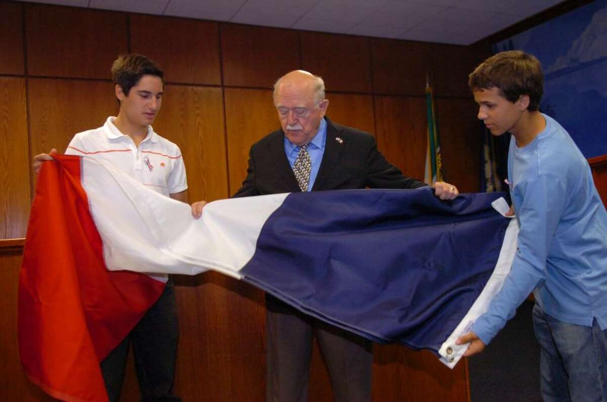 Serge Gabriel, of Greenwich, chairman of the town's Bastille Day celebration, with his grandsons, Hakan Karabey, 17, of New York, N.Y., left, and Michael Schobitz,16, of Munich, Germany, unfold the French flag in preparation to raise the flag at Town Hall, on Wednesday, July 14, 2010.