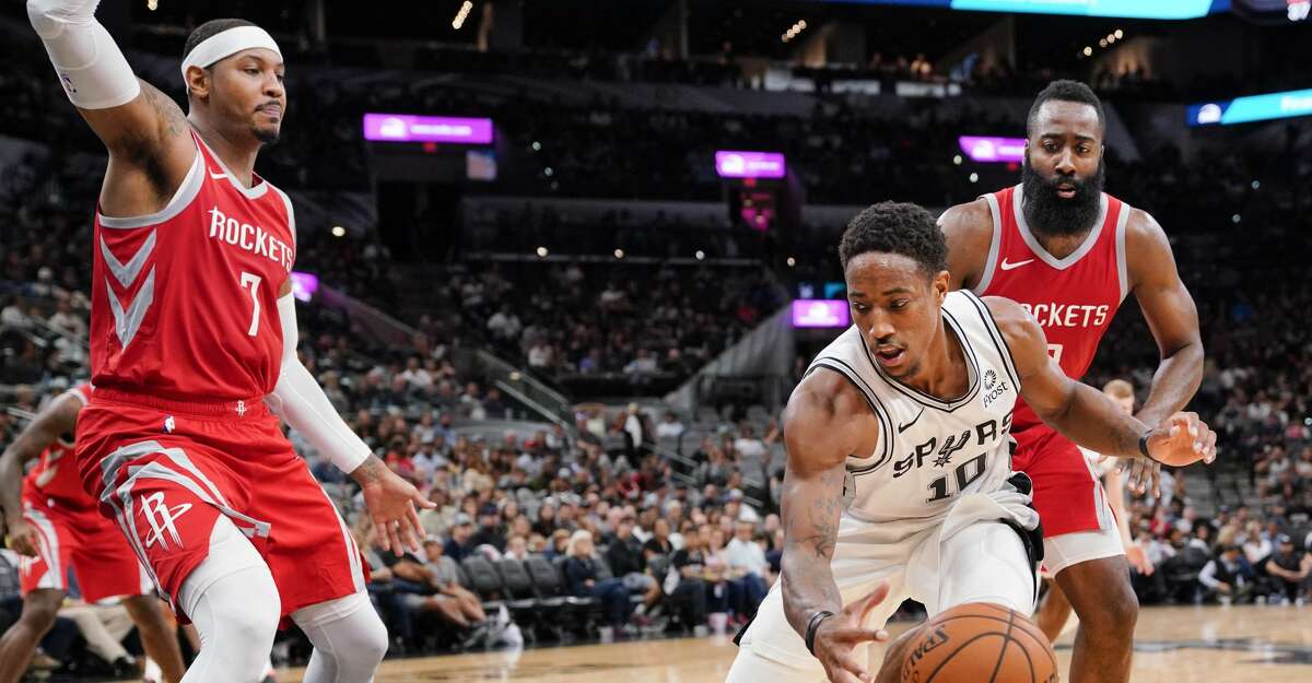 San Antonio Spurs' DeMar DeRozan (10) tangles with Houston Rockets' Carmelo Anthony (7) and James Harden during the second half of an NBA preseason basketball game, Sunday, Oct. 7, 2018, in San Antonio. (AP Photo/Darren Abate)