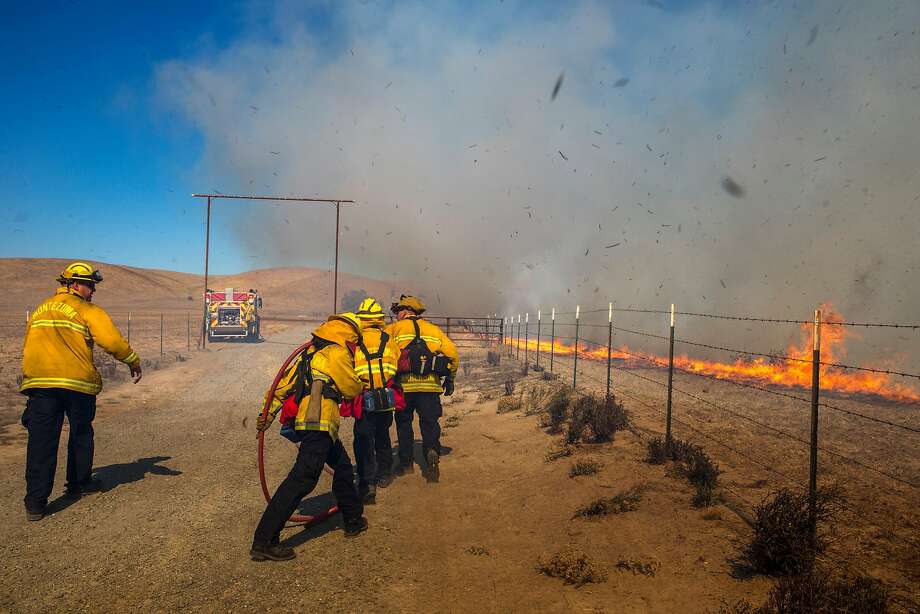 Firefighters fight a wild grass fire with gusts of wind blowing at over 20 km / h, lifting debris and burning over 4,000 hectares of land on a ranch and preserving land near the Wildlife Sanctuary. Grizzly Island on Sunday, October 7, 2018 in Solano County, California. Photo: Peter DaSilva / Peter DaSilva