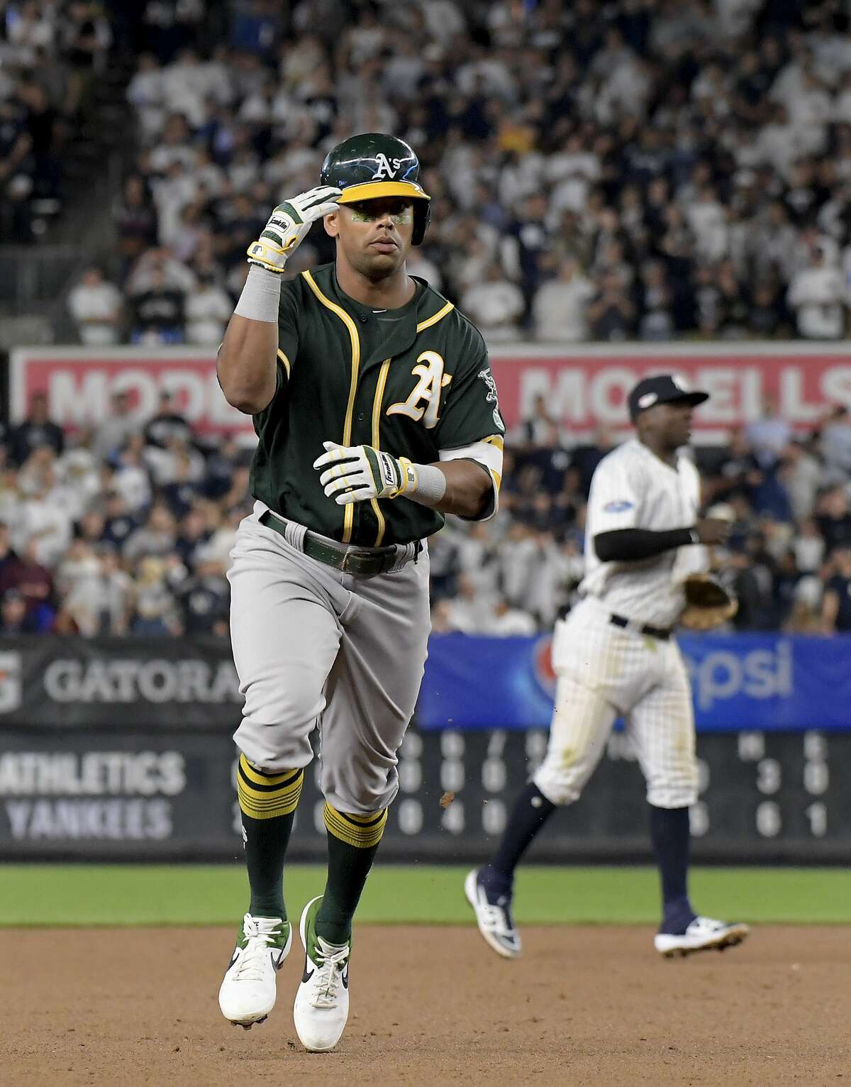 Oakland Athletics' Khris Davis reacts as he rounds the bases after hitting a two-run home run against the New York Yankees during the eighth inning of the American League wild-card playoff baseball game, Wednesday, Oct. 3, 2018, in New York. (AP Photo/Bill Kostroun)