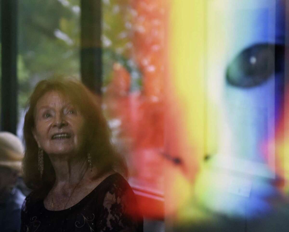 Old Greenwich resident Lucie Anderes is reflected in a photograph by Andrew Conner on display during the opening reception of the Art Society of Old Greenwich's Autumn Members Show at the Garden Education Center in the Cos Cob section of Greenwich, Conn. Sunday, Oct. 7, 2018. Works in a variety of mediums were presented at the show, judged by UConn Art & Art History Department Head John Richardson. The art will be on display until Oct. 28.