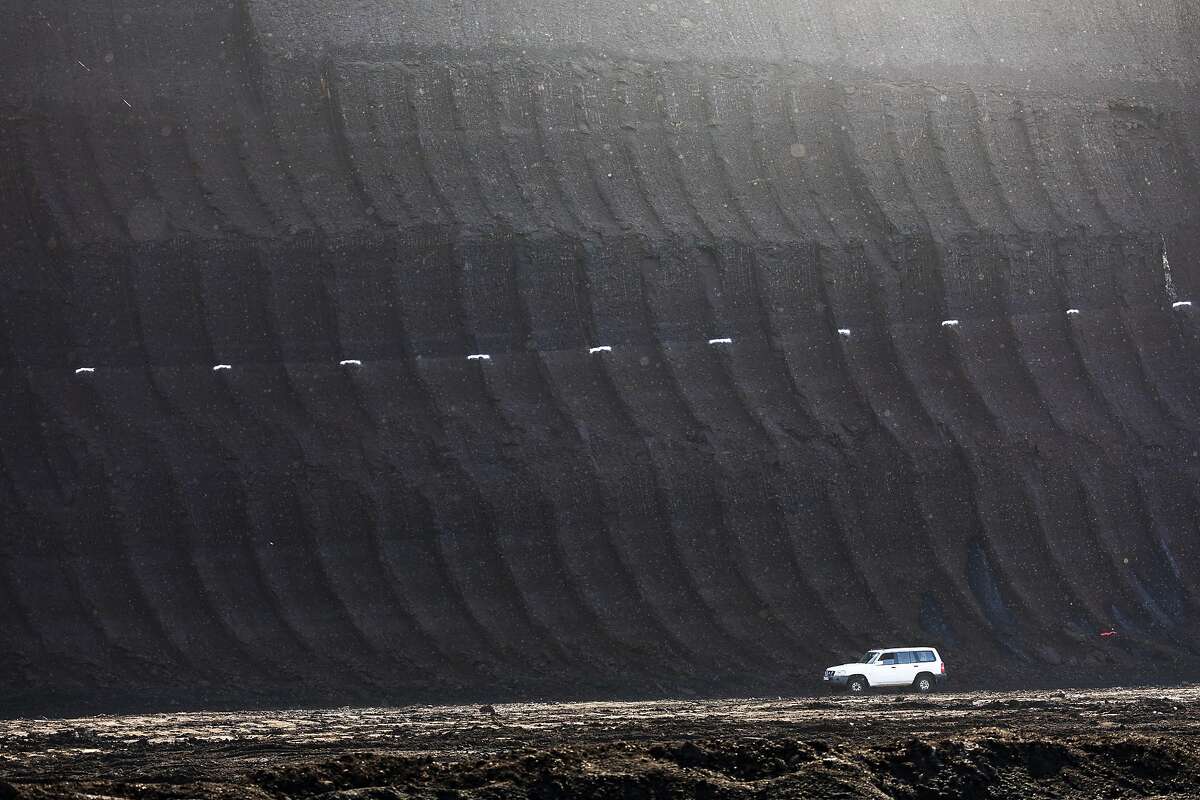 White markers indicate a coal rich area of excavated earth at the open pit lignite mine, operated by RWE AG, in Hambach, Germany, on Friday, Oct. 5, 2018. The world must invest $2.4 trillion in clean energy every year through 2035 and cut the use of coal-fired power to almost nothing by 2050 to slow the quickest pace of climate change since the end of the last ice age, according to scientists convened by the United Nations. Photographer: Alex Kraus/Bloomberg