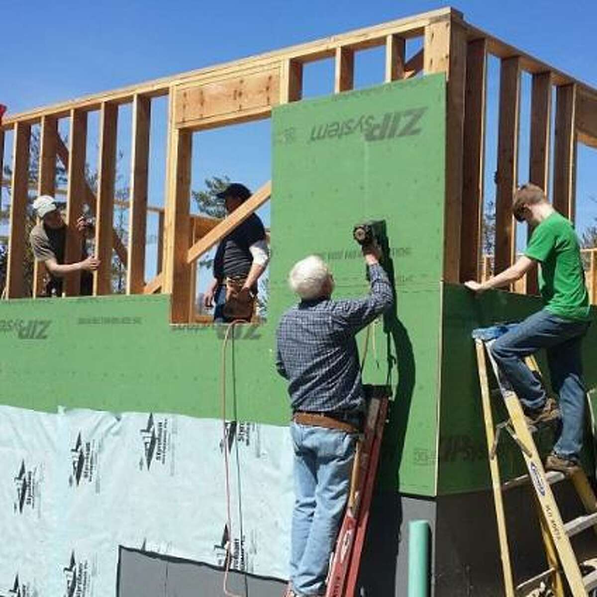 Above, volunteers work on a Habitat for Humanity house.