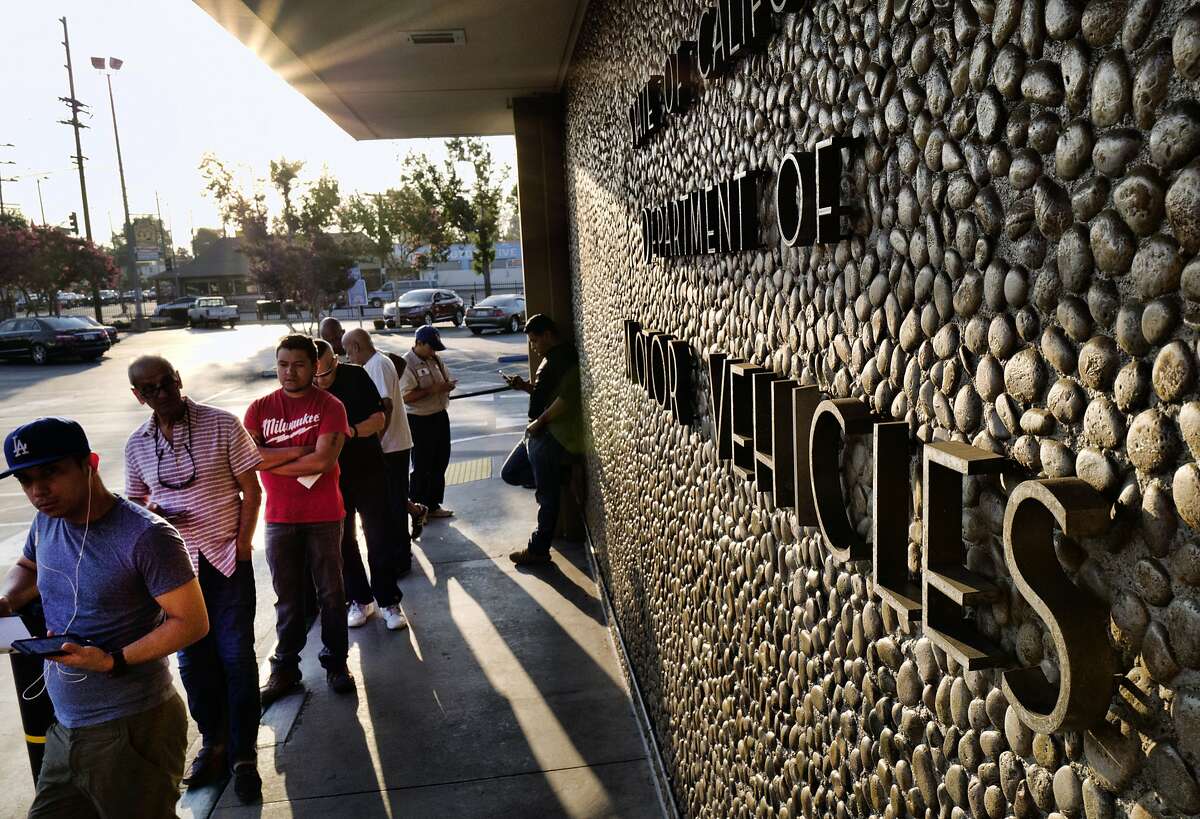 FILE - In this Tuesday, Aug. 7, 2018, file photo, people line up at the California Department of Motor Vehicles prior to opening in the Van Nuys section of Los Angeles. California Gov. Jerry Brown is ordering an audit the Department of Motor Vehicles in light of long wait times. The state's department of finance will perform the audit, looking into information technology and customer service. A Friday, Sept. 21, 2018, letter from Finance Director Keely Bosler tells DMV Director Jean Shiomoto the audit will assess information technology and customer service. (AP Photo/Richard Vogel, File)