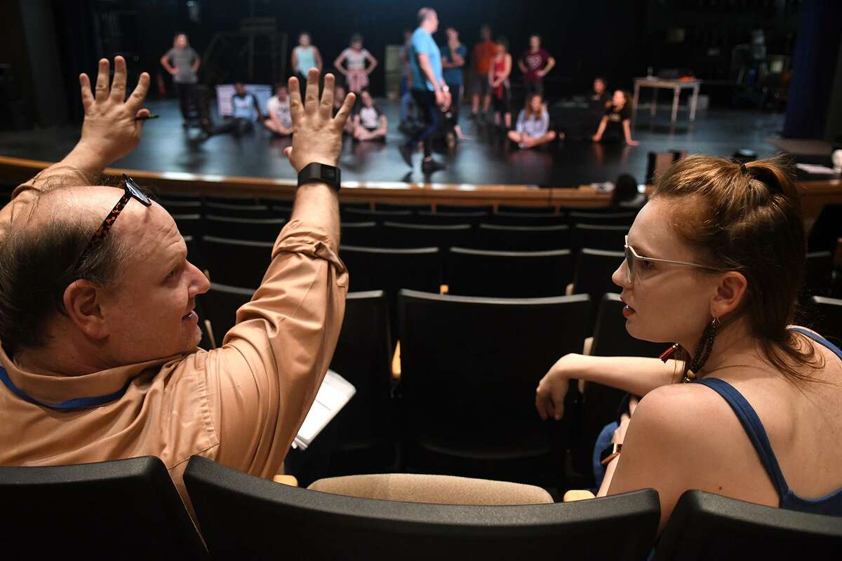 Director Michael Montgomery, of Cypress, left, and Courtney Berry, 26, of Spring, who is playing the part of the "Ghost of Christmas Past" in the upcoming Stageworks Theatre production of "A Christmas Carol", chat off stage during a rehearsal at The Lone Star College - Cy-Fair Performing Arts Center on Sept. 26, 2018.